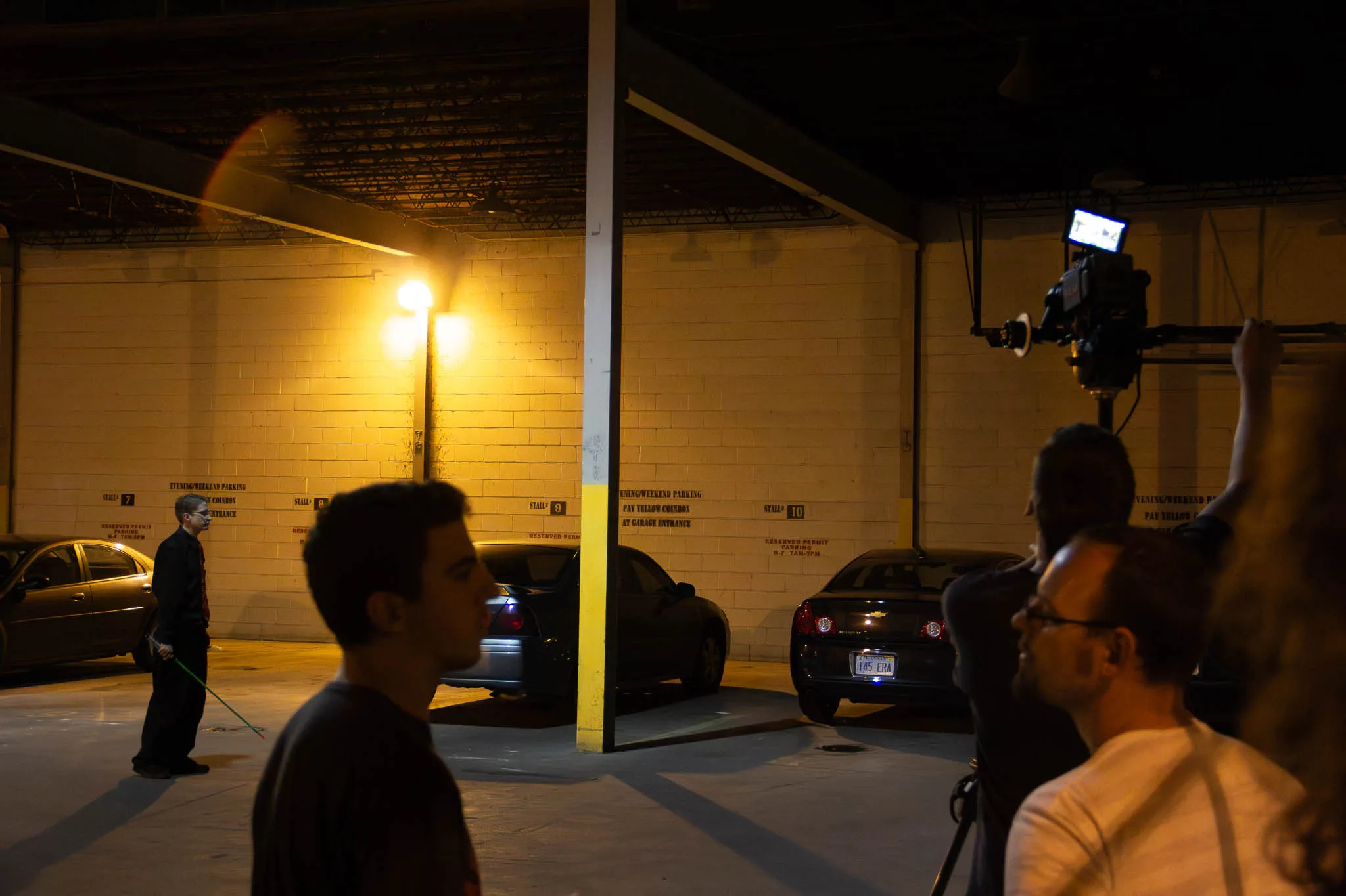 Zach and Eric converse in the forgeground while my awkward self prepares for a take.